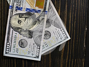 Two hundred dollars bills on a wooden background. new hundred dollar bill. Close up american dollar banknotes