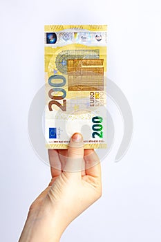 Two hundred euro banknote in woman`s hand. Concept of paying taxes in the end of a year