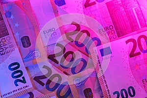 Two hundred euro in purple neon light. Money colored background.Inflation of money in the EU countries.Euro exchange