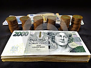 Two hundred thousand Czech crowns in banknotes stacked on top of each other for which Czech fifty crowns are stacked in columns,