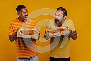 Two hungry friends screaming with thrill holding pizza while standing isolated