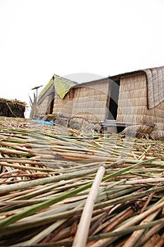 Two huts made of reeds by the native indians that are standing in a man made island at Lake Titicaca in Peru, South America