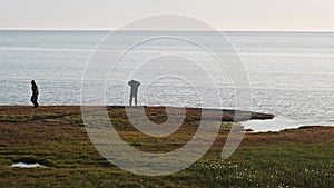 Two hydrologists wearing antimosquito screens on their heads examine ground and make measures. Descover Yamal peninsula.