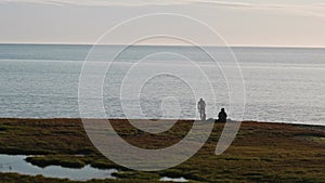 Two hydrologists wearing antimosquito screens on their heads examine ground and make measures. Descover Yamal peninsula.