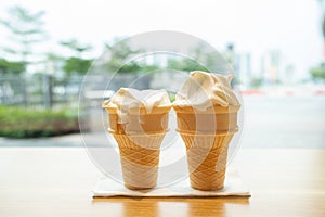 two ice cream cones with couple of bites on table horizontal composition