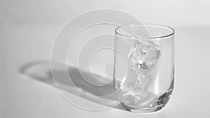 Two ice cubes in a super slow motion rebounding in a glass