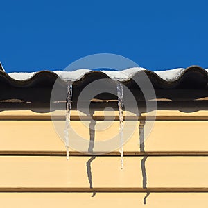 Two icicles hanging from the roof