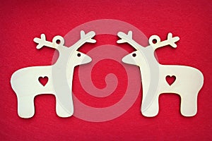Two identical Christmas deer on textured red background.Free space for text