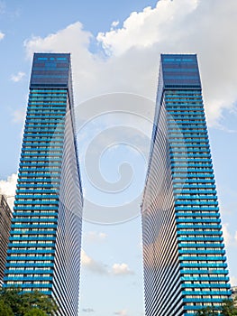Two identical high-rise buildings. Blue skyscrapers. Orbi city. Modern city development