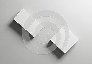 Two identical white and gray boxes standing side by side on a gray surface