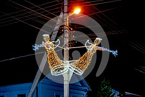 Two illuminated sculptures of angels on an electric pole on Kanatna Street in Kherson Ukraine