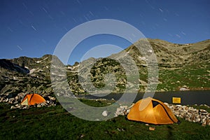 Two illuminated tents in the night