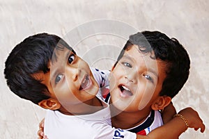 Two indian young baby boy brothers hugging each other