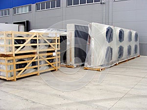 Two industrial air coolers neatly stacked on a wooden pallet at a construction site