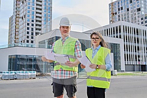 Two industrial construction workers discussing project plan for engineering work