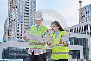 Two industrial construction workers discussing project plan for engineering work