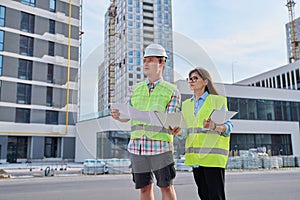 Two industrial construction workers discussing project plan for engineering work