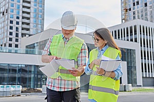 Two industrial construction workers discussing project plan for engineering work