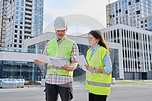 Two industrial construction workers discussing project plan for engineering work