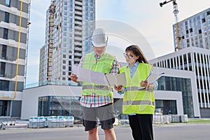 Two industrial construction workers discussing project plan for engineering work