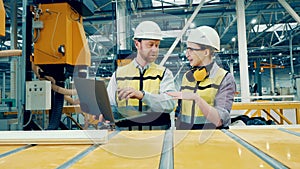 Two industrial engineers are discussing fiberglass production