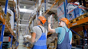 Two inspectors talk during work at a warehouse in a back view.