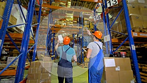 Two inspectors walk through a giant warehouse.