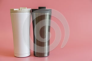 two insulated cups on a pink background.