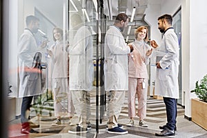 Two intercultural male healthcare workers and their female colleague having talk