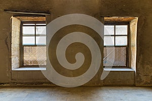 Two Interleaved grunge wooden ornate windows - Mashrabiya - in stone wall at abandoned building photo