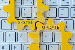 Two interlocking gear with text SYSTEM UPDATE on a computer keyboard.