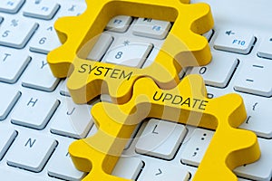 Two interlocking gear with text SYSTEM UPDATE on a computer keyboard.