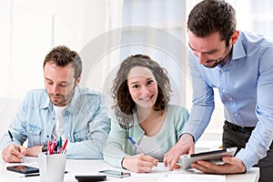 Two interns working together assisted by their course supervisor