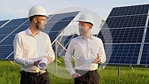 Two investors businessmen walking and examining photovoltaic solar panels