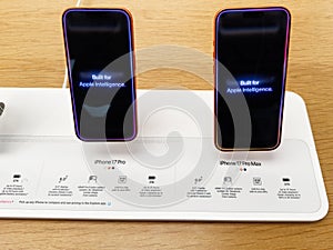 Two iPhone 17 Pro Max models on display stand showcasing Apple Intelligence screens