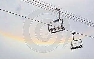 Two isolated empty chairs on a ski lift