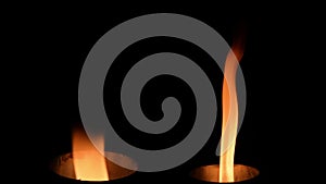 Two isolated fire flames, slow motion gas ignition from bottom to top, high speed flamethrower on black background. The