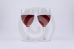 Two isolated glasses full of red wine on white background