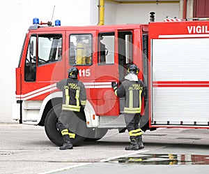 two Italians firefighters descend from fire trucks