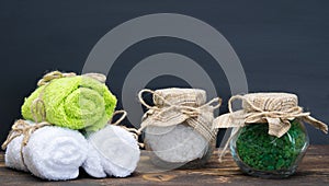 Two jars with salt and three towels on the table and there is a place