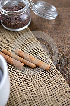 Two jars with sugar confectionery additives and cinnamon sticks