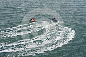 Two jet skis or personal watercraft speeding across the ocean