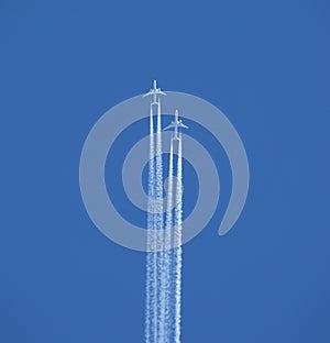 Two jet two-turbine aircraft in flight on blue sky background