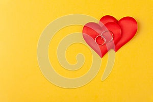 Two jewel round golden rings on red hearts, concept love, gift, proposal of marriage on dating, valentines day surprise