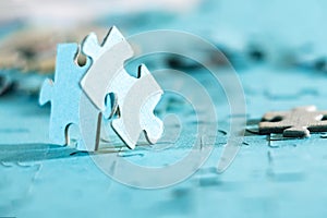 Two jigsaw puzzle pieces on a table joint together.