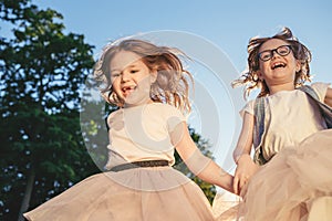 Two joyful girls running against the sunset.