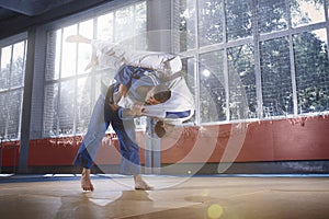 Two judo fighters showing technical skill while practicing martial arts in a fight club