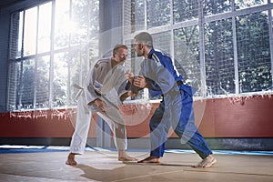 Two judo fighters showing technical skill while practicing martial arts in a fight club