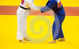 Two judo fighters in white and blue uniform