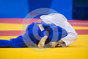 Two judo fighters in white and blue uniform